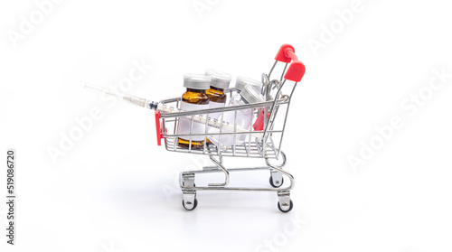 A bottle of vaccine and syringe in a shopping cart on a white background. © supaleka