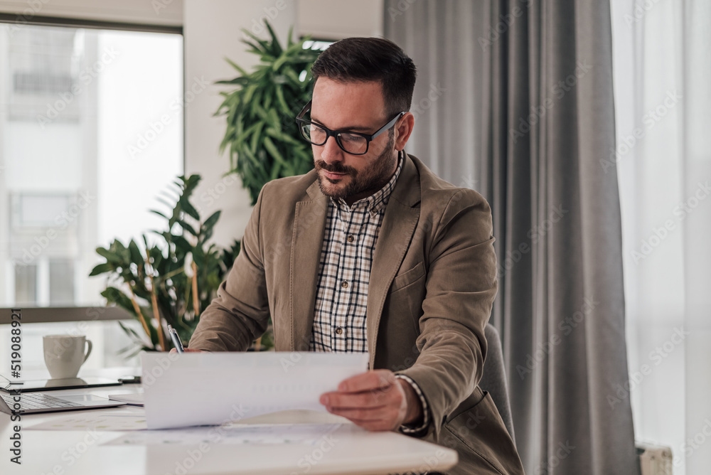Fototapeta premium Serious professional analyzing business plan while working at corporate office