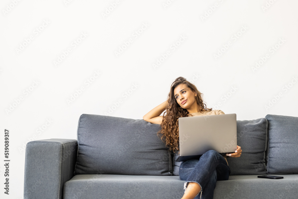 Happy pretty woman using laptop sitting on sofa Happy pretty woman using laptop sitting on sofa