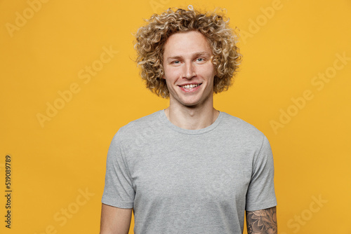 Fényképezés Young smiling happy fun cheerful cool blond caucasian european man 20s he wearing basic grey t-shirt lookig camera isolated on plain yellow color backround studio portrait