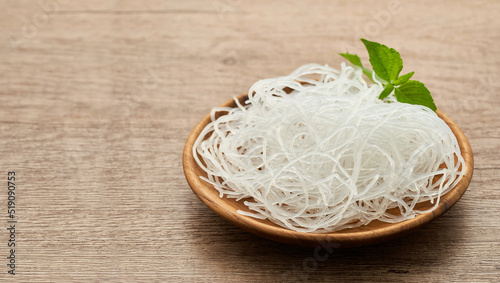 Asian vermicelli or cellophane noodle in wooden plate on wood table background. glass noodle                                                                              