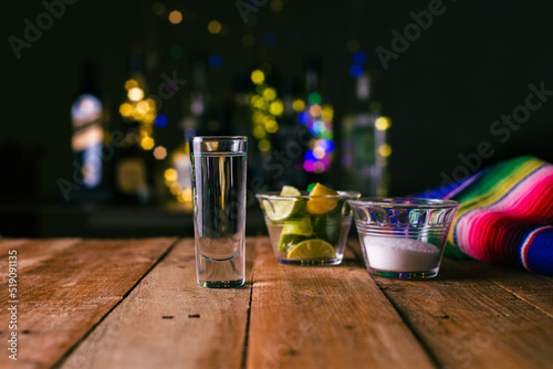 Photo Shot of tequila served in a tequila glass on a wooden table