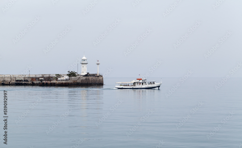 Coastal view of Yalta. Small passenger ferry ship nd Lighthouse