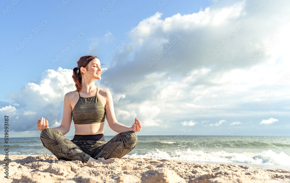 Woman in lotus position on beach. Girl enjoys meditation outdoors. Yoga harmony of soul and body healing Woman in lotus position on beach. Girl enjoys meditation outdoors. Yoga harmony of soul and body healing