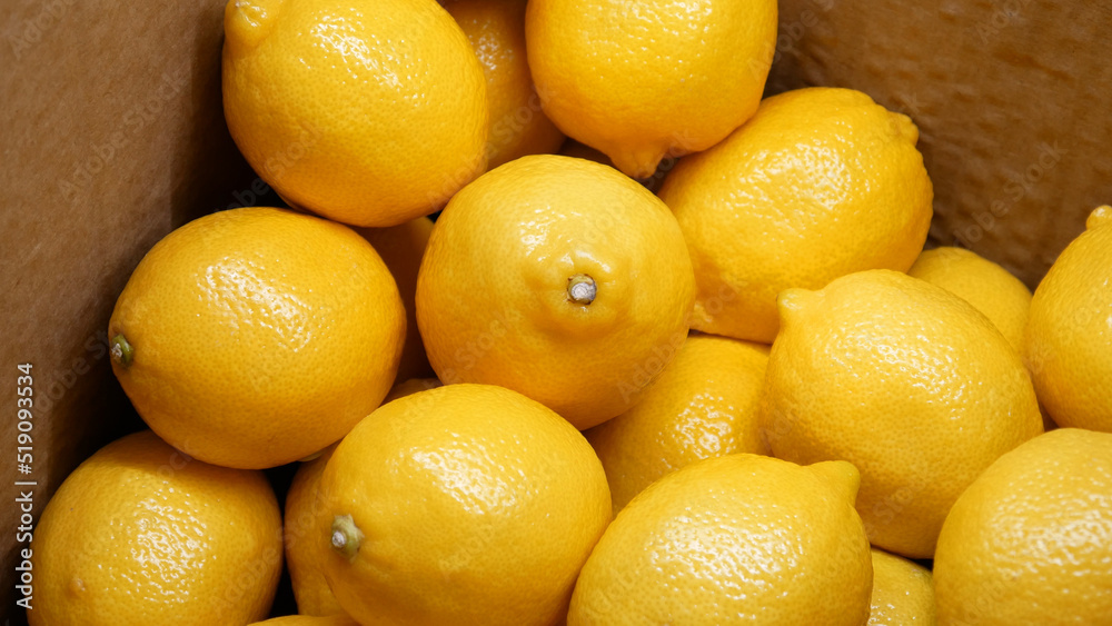 Close-up of many beautiful ripe lemons in a carton box Close-up of many beautiful ripe lemons in a carton box