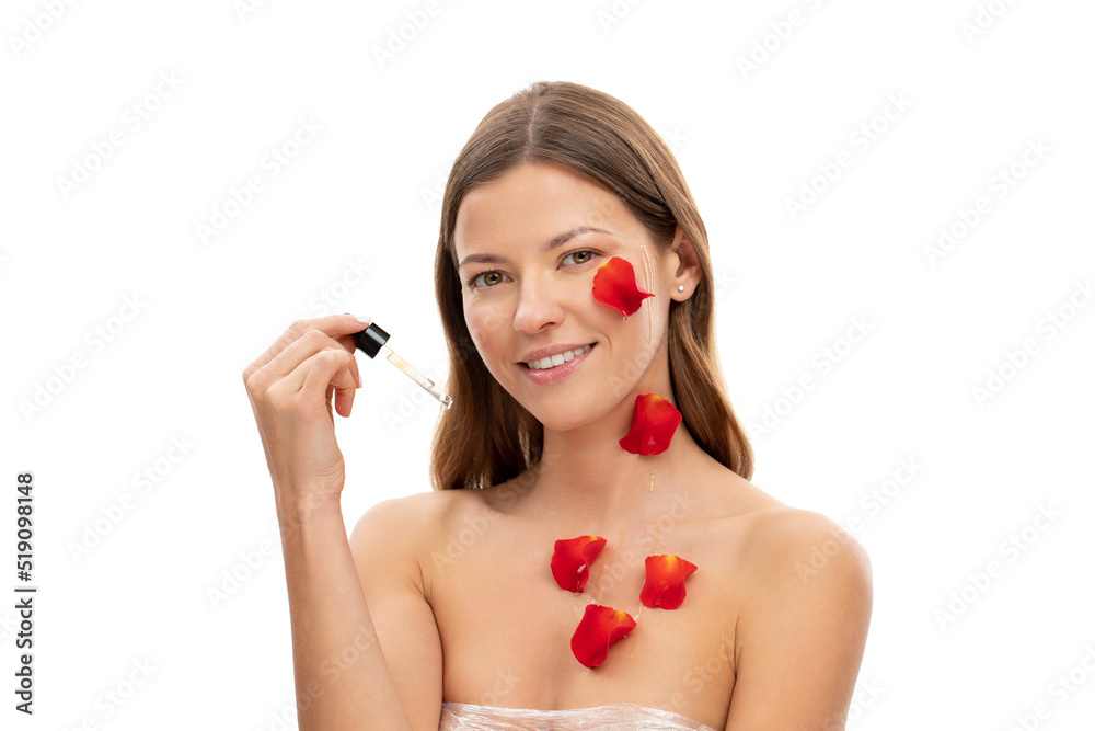 Close up photo of the face of young woman covered with rose petals. Woman holding face serum Close up photo of the face of young woman covered with rose petals. Woman holding face serum