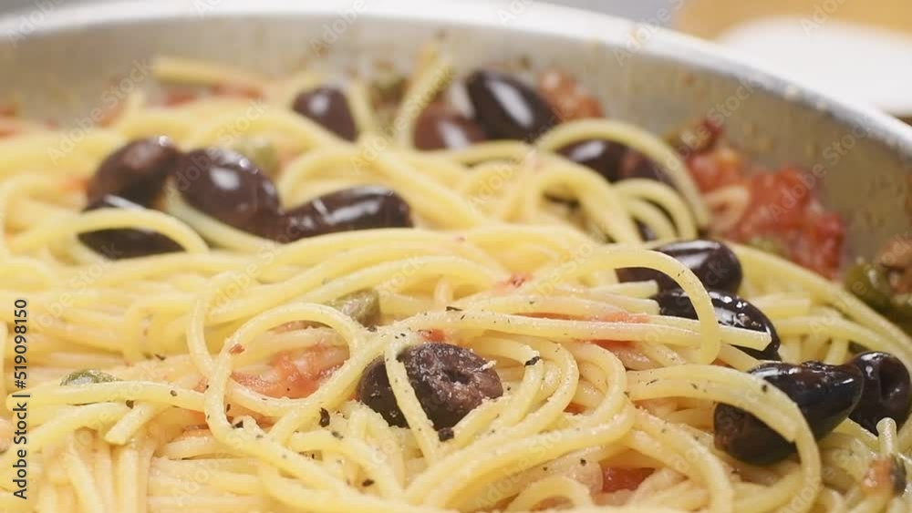 Cooking of spaghetti in a pan. Chef sprinkles black pepper on the spaghetti.
Cooking of spaghetti in a pan. Chef sprinkles black pepper on the spaghetti.