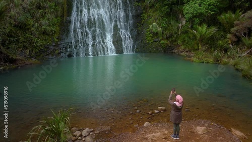 Female visiting Karekare falls, west Auckland, New Zealand photo