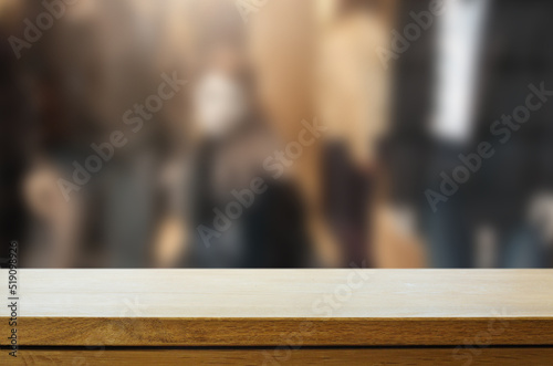 Art Empty wooden deck table over blurred fashion boutique background.