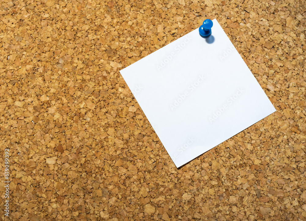 Blue pinned note paper on a cork board Blue pinned note paper on a cork board