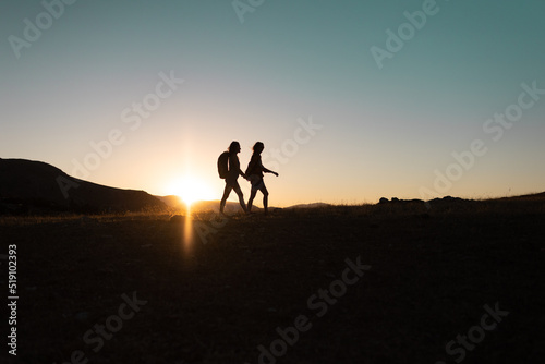 two people walk along a mountain range © zhukovvvlad