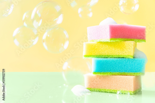Cleaning concept - colorful dishwashing sponges on bright background