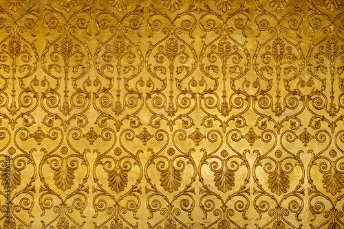 Gold ornamental pattern, wall background texture. Retro art decoration photo