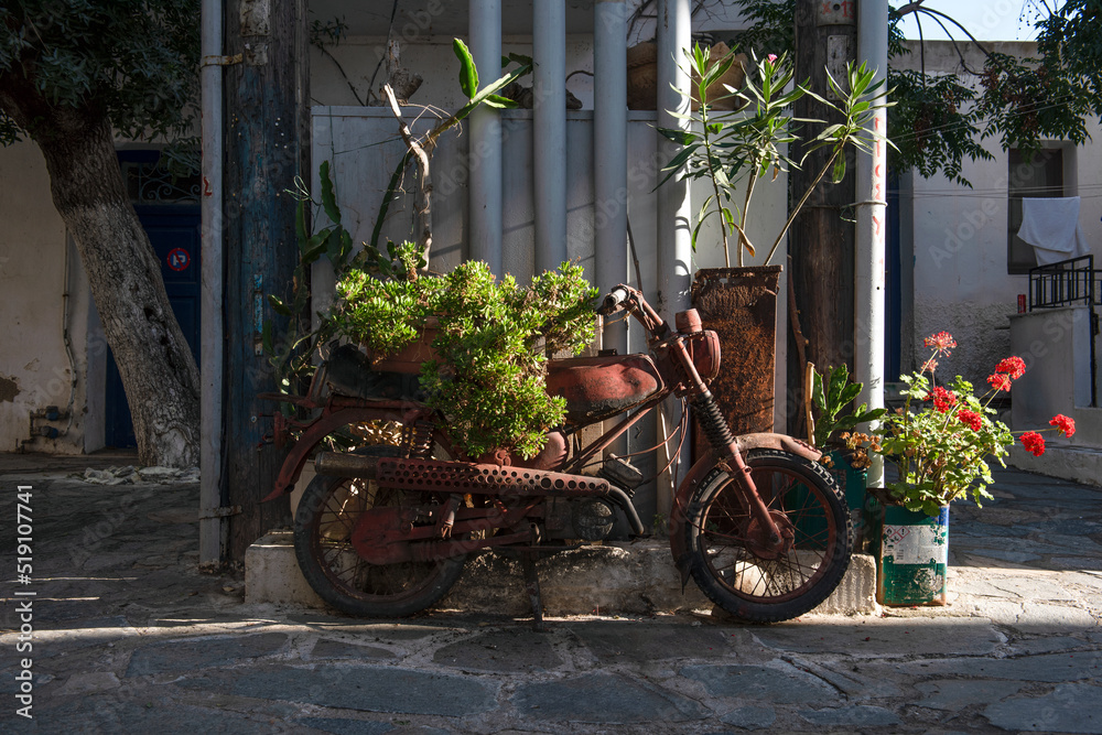 Rusty motorcycle in Naxos town in Greece. Beautiful vintage image. 