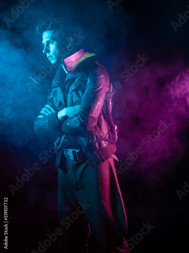 A guy in a cyberpunk image, a futuristic character in smoke. A young man in neon lighting on a black background
