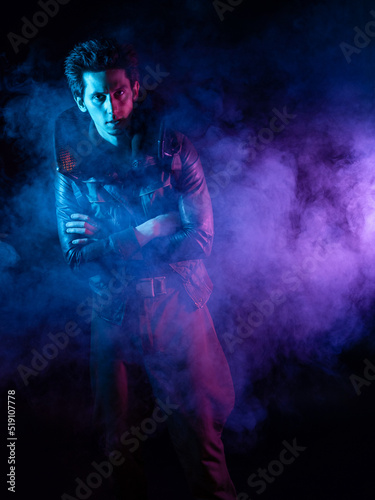 A guy in a cyberpunk image, a futuristic character in smoke. A young man in neon lighting on a black background