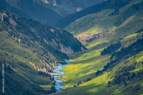 Long focus picture of Adishi village in deep mountain canyon. Splendid summer scene of Upper Svaneti, Georgia. Beautiful morning landscape of Caucasus Mountains. Traveling concept background.. photo
