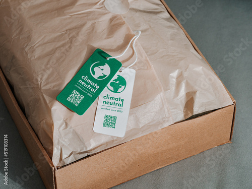 Carbon neutral product in craft corrugated box with label Climate neutral. Carbon neutral label concept in apparel, fashion, logistics indusrty and ethical consumption. Increasing awareness for