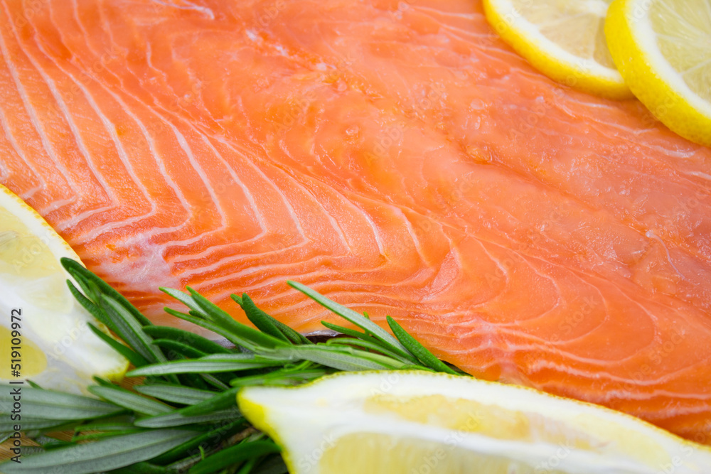 Salmon fillet with lemon and rosemary close-up. Red fish with spices.