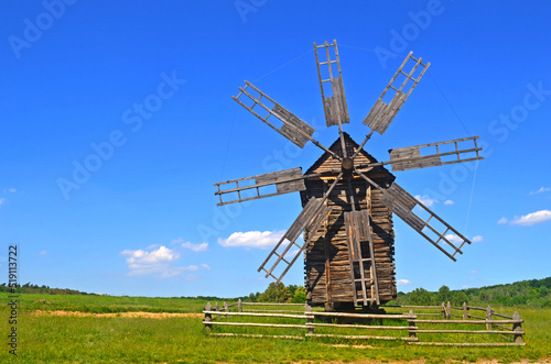 An old wooden, windmill. Rustic summer landscape. Greenfield. Ukraine. National Museum of Folk Architecture and Life. Open-air museum.