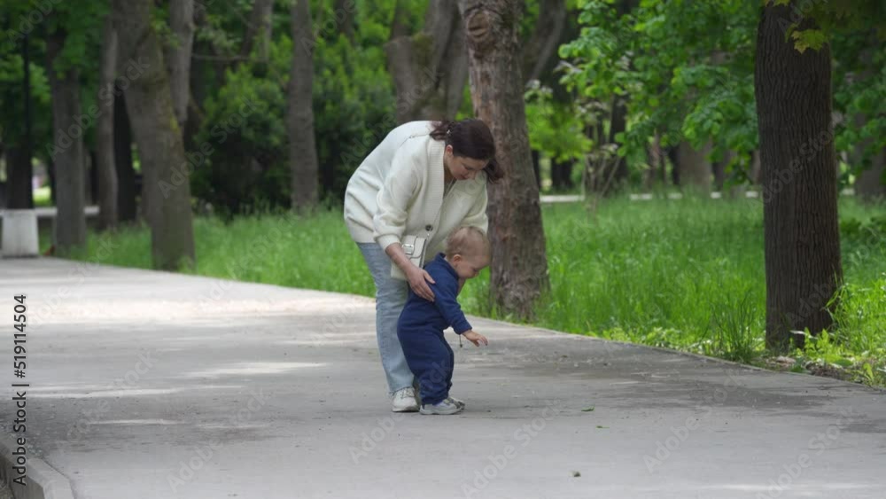 Mother and child walking in the park in summer, happy 1.5 year old toddler learns to walk. Mother and child walking in the park in summer, happy 1.5 year old toddler learns to walk.