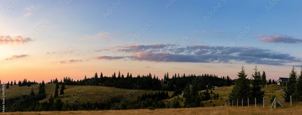 Beautiful sunset landscape with mountains and trees - panorama