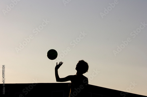 Silhouette of a girl and a ball in golden hour