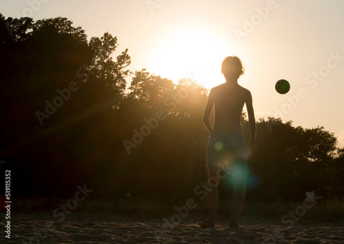 Silhouette of a girl and a ball in golden hour
