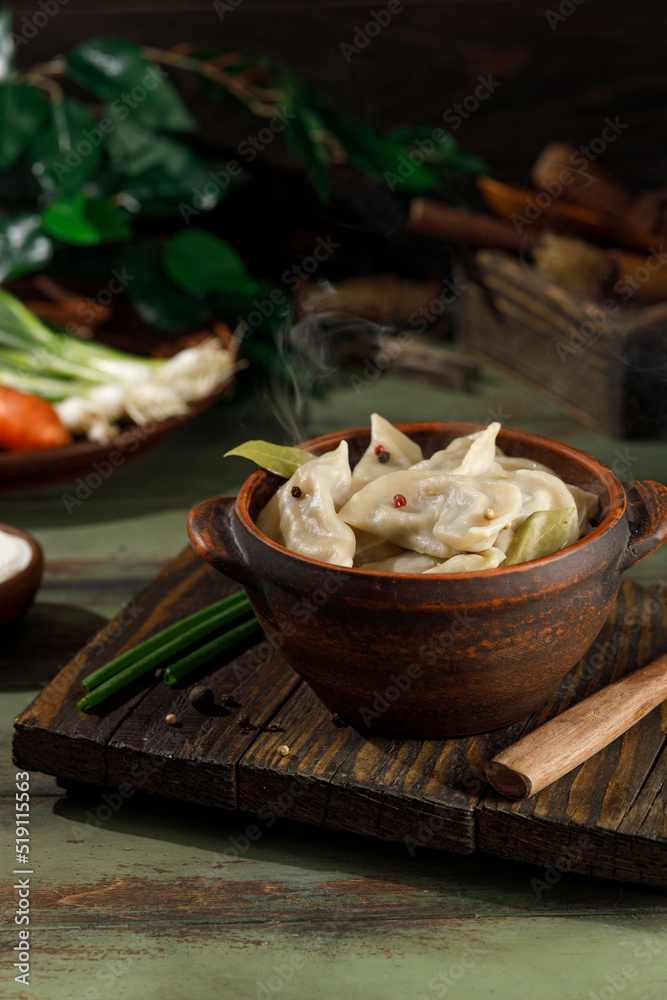 ready-made dumplings with potatoes and mushrooms in a plate on a wooden table. The wooden fork lies to the right of the plate. Close frame ready-made dumplings with potatoes and mushrooms in a plate on a wooden table. The wooden fork lies to the right of the plate. Close frame