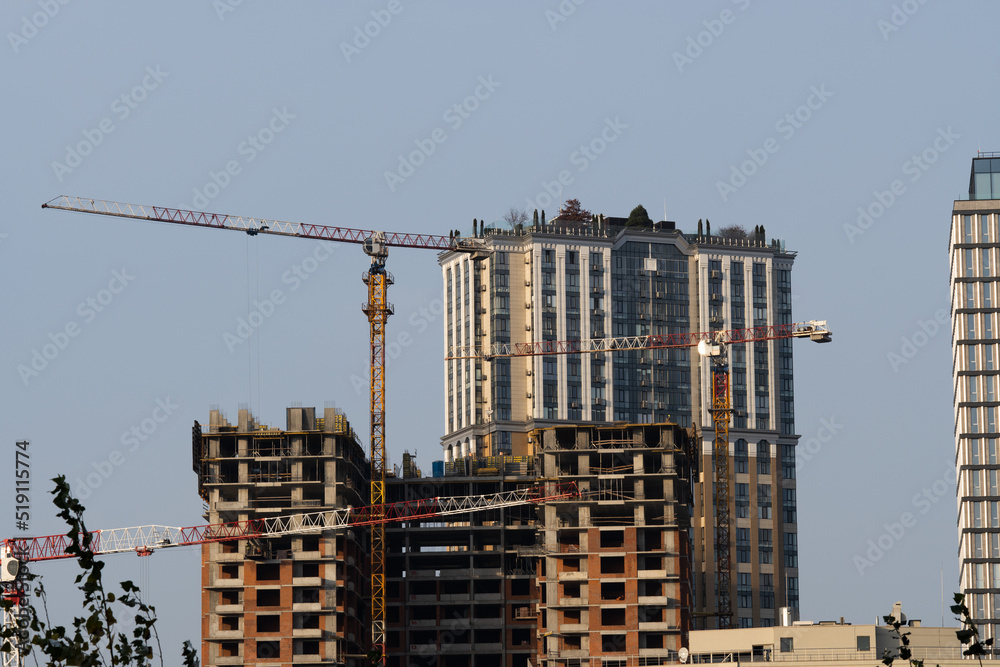 Construction site. High-rise multi-storey buildings are being built. Tower cranes near buildings. Industrial background Construction site. High-rise multi-storey buildings are being built. Tower cranes near buildings. Industrial background