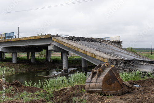 Destroyed bridge across the river The civilian facility was blown up. War in Ukraine. Destroyed infrastructure. Broken communications. humanitarian catastrophe