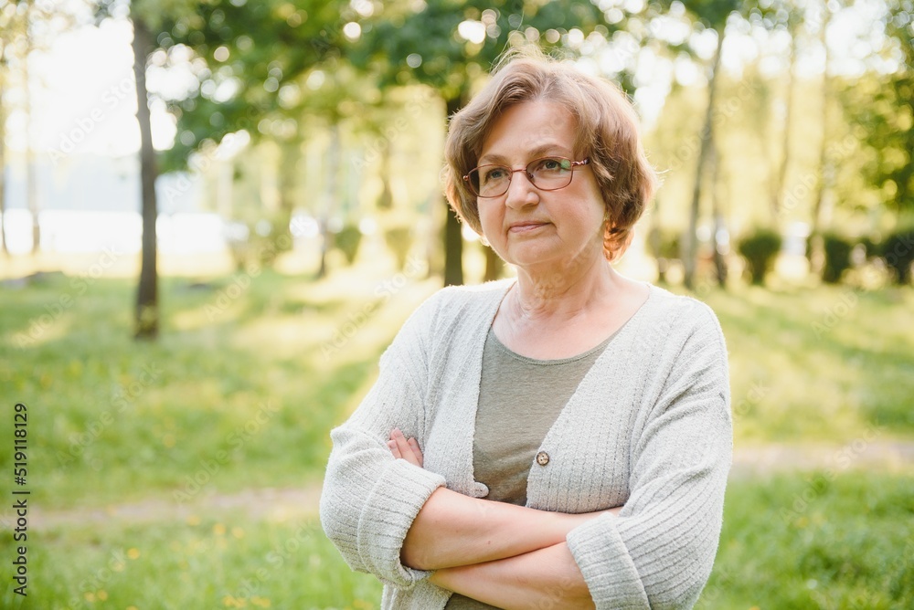 Senior woman walking in the park in summer. Senior woman walking in the park in summer.