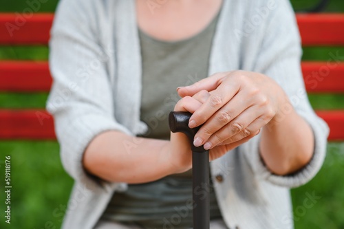 Elderly woman sitting and relaxing on a bench outdoors in park