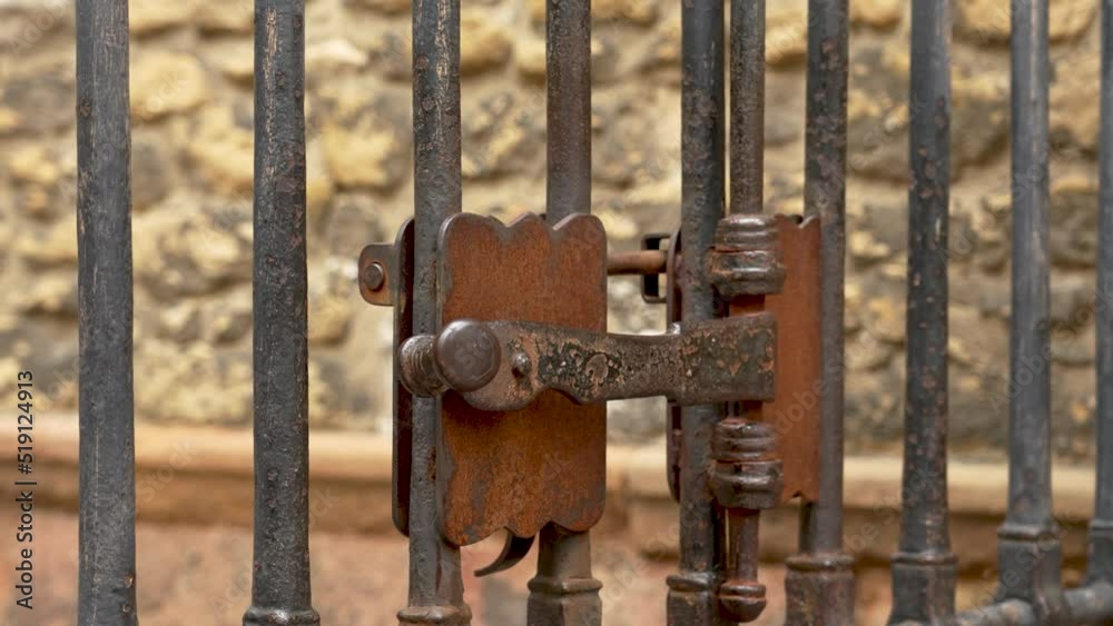 Ancient metal rusty wrought handle deadbolt (latch) of closed door of the lattice gate of the antique cathedral in Spain closeup. Mechanical medieval lock Ancient metal rusty wrought handle deadbolt (latch) of closed door of the lattice gate of the antique cathedral in Spain closeup. Mechanical medieval lock