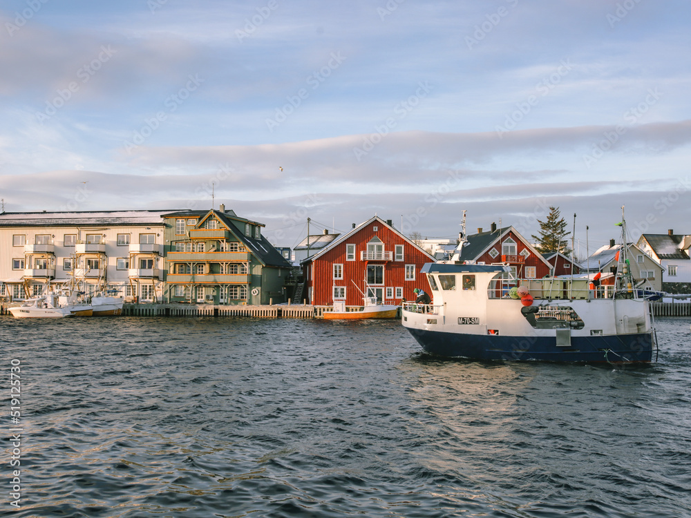 Nordic harbor with a fishing boat of cod in Lofoten. Sunset light at winter season in the Artic Circle