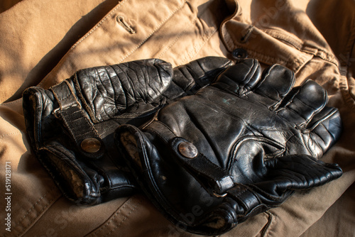 Black vintage motorcycle gloves. Leather motorcycle gloves from the 1950's. Classic design icon with leather buckle strap and a worn retro look. Worn by rebels and bikers. Very stylish rugged