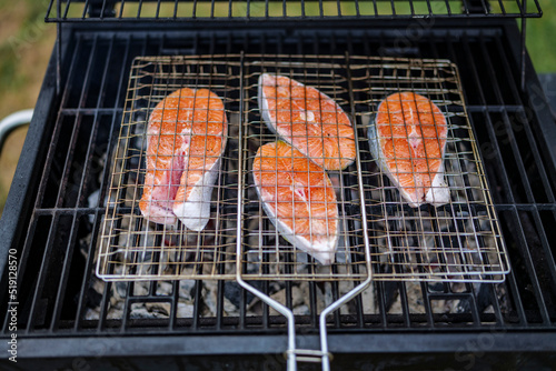 grilled salmon steaks are coking on the firewood, in the backyard. High-quality photo