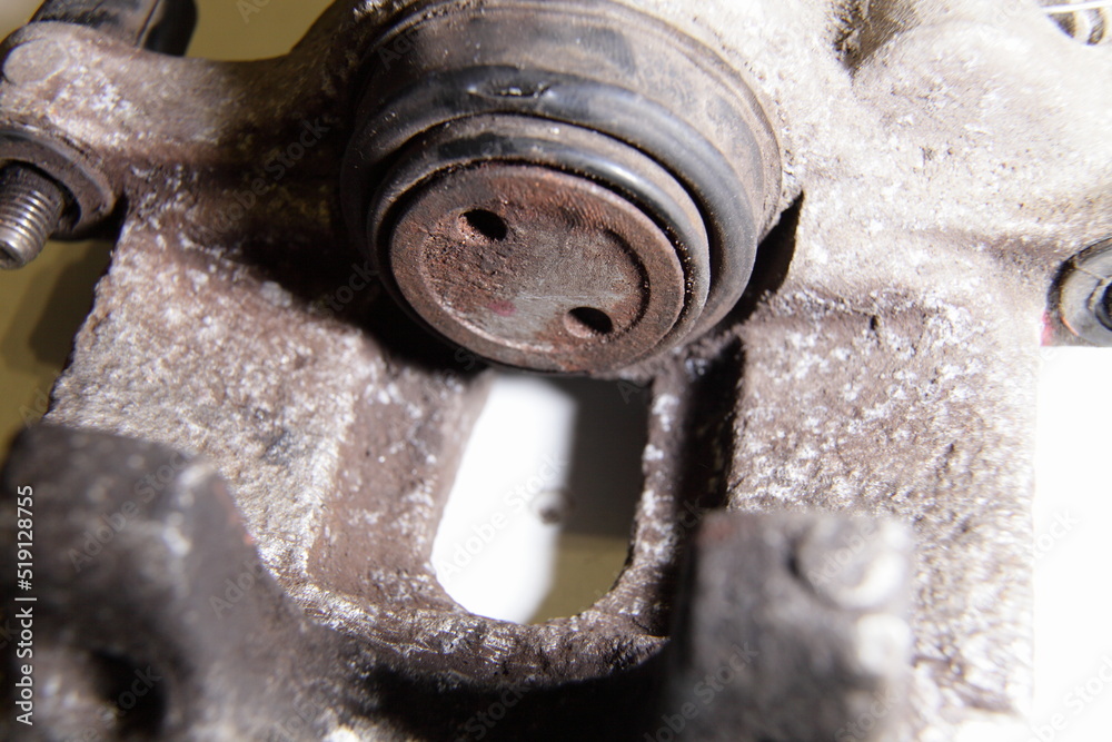 Old single piston hydraulic brake caliper with broken brake piston cup close up, car brakes repair