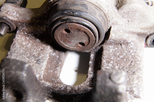 Old single piston hydraulic brake caliper with broken brake piston cup close up, car brakes repair