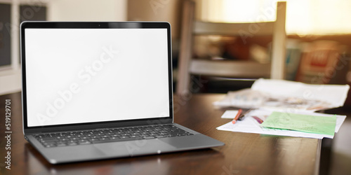 Obraz na plátně Mockup image of laptop with blank white desktop screen on a wooden table in an ordinary apartment