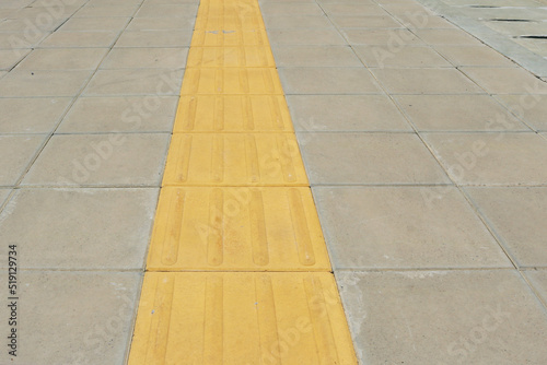 Braille block yellow installed on concrete footpath. 