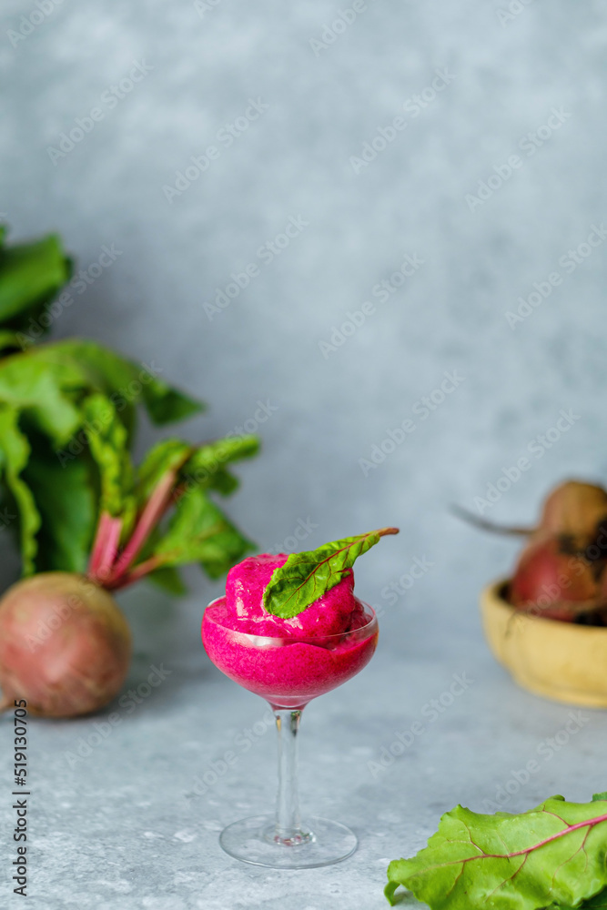Magenta vegan ice cream with frozen beetroot, banana, avocado and coconut milk in glass on a gray background. A healthy cold vegan dessert. Magenta vegan ice cream with frozen beetroot, banana, avocado and coconut milk in glass on a gray background. A healthy cold vegan dessert.