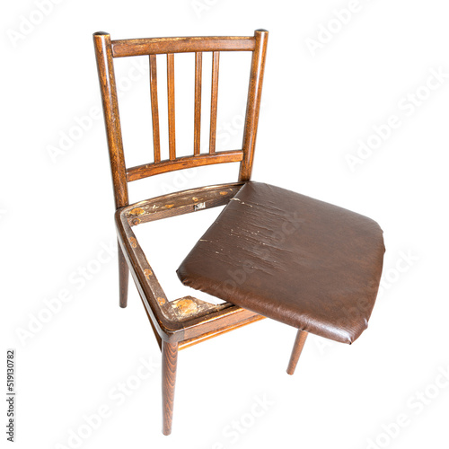 Broken dining chair with a shabby seat on white