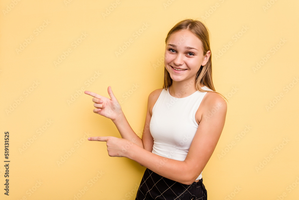 Young caucasian girl isolated on yellow background pointing with forefingers to a copy space, expressing excitement and desire. Young caucasian girl isolated on yellow background pointing with forefingers to a copy space, expressing excitement and desire.