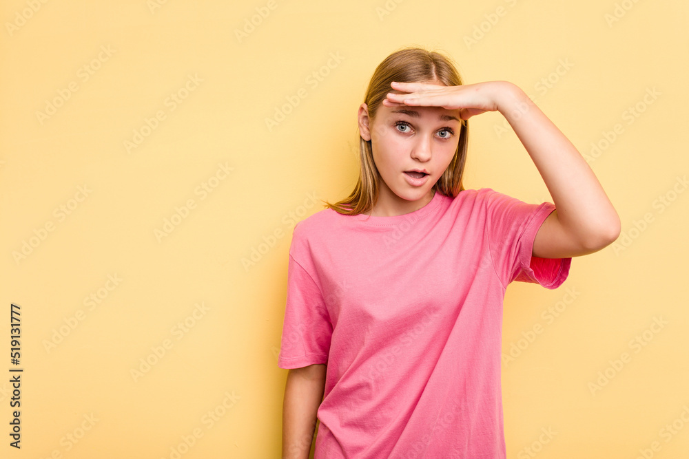 Fototapeta premium Young caucasian girl isolated on yellow background looking far away keeping hand on forehead.