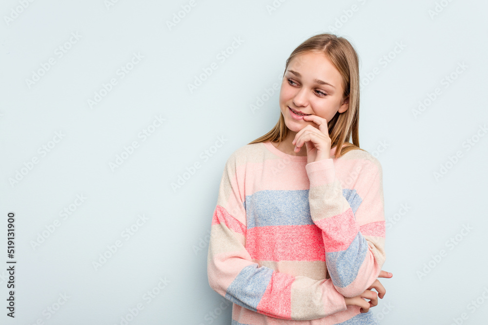 Young caucasian girl isolated on blue background relaxed thinking about something looking at a copy space. Young caucasian girl isolated on blue background relaxed thinking about something looking at a copy space.