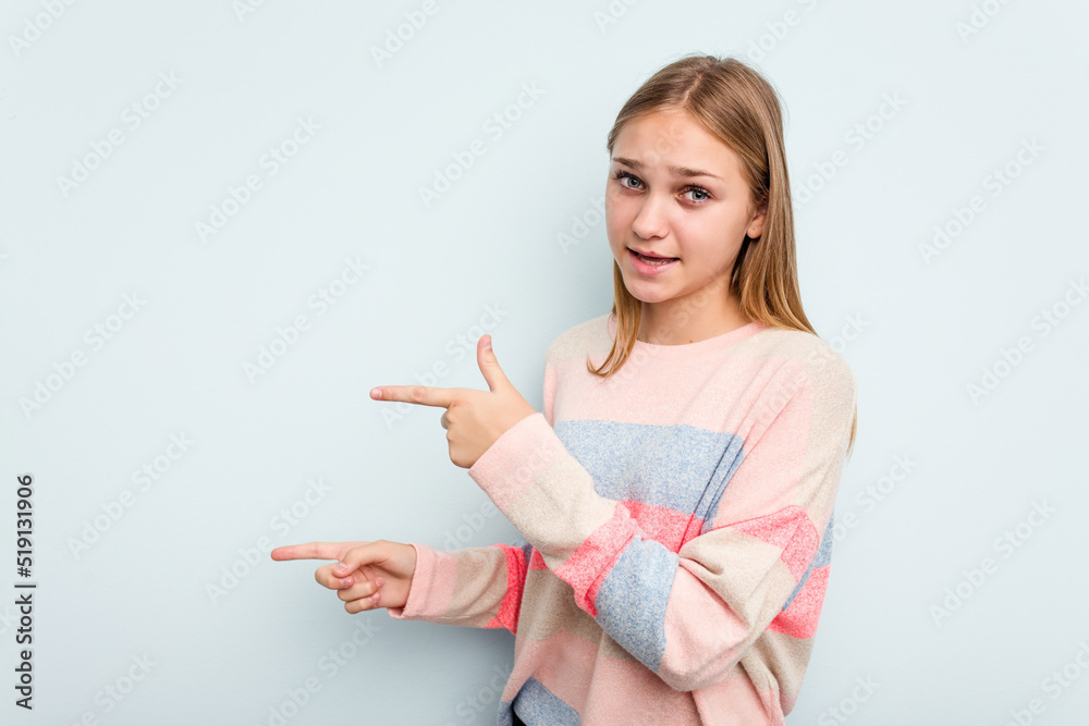 Young caucasian girl isolated on blue background pointing with forefingers to a copy space, expressing excitement and desire. Young caucasian girl isolated on blue background pointing with forefingers to a copy space, expressing excitement and desire.