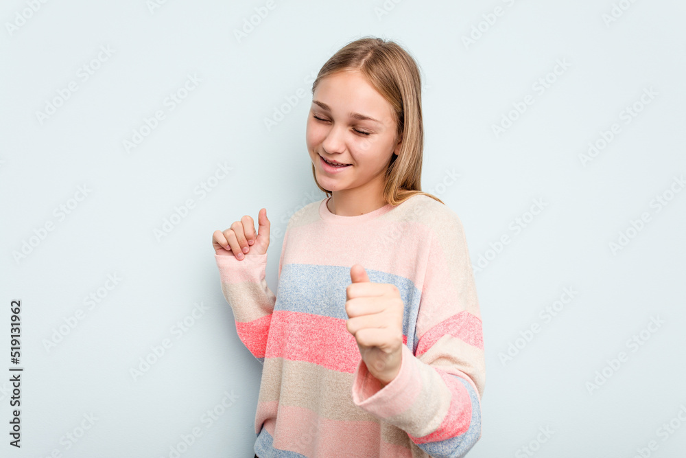 Young caucasian girl isolated on blue background dancing and having fun. Young caucasian girl isolated on blue background dancing and having fun.