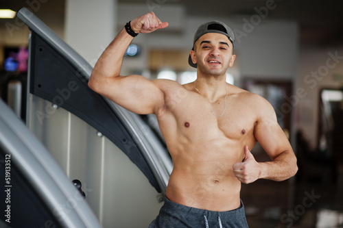 Fit and muscular arabian man posing in gym.