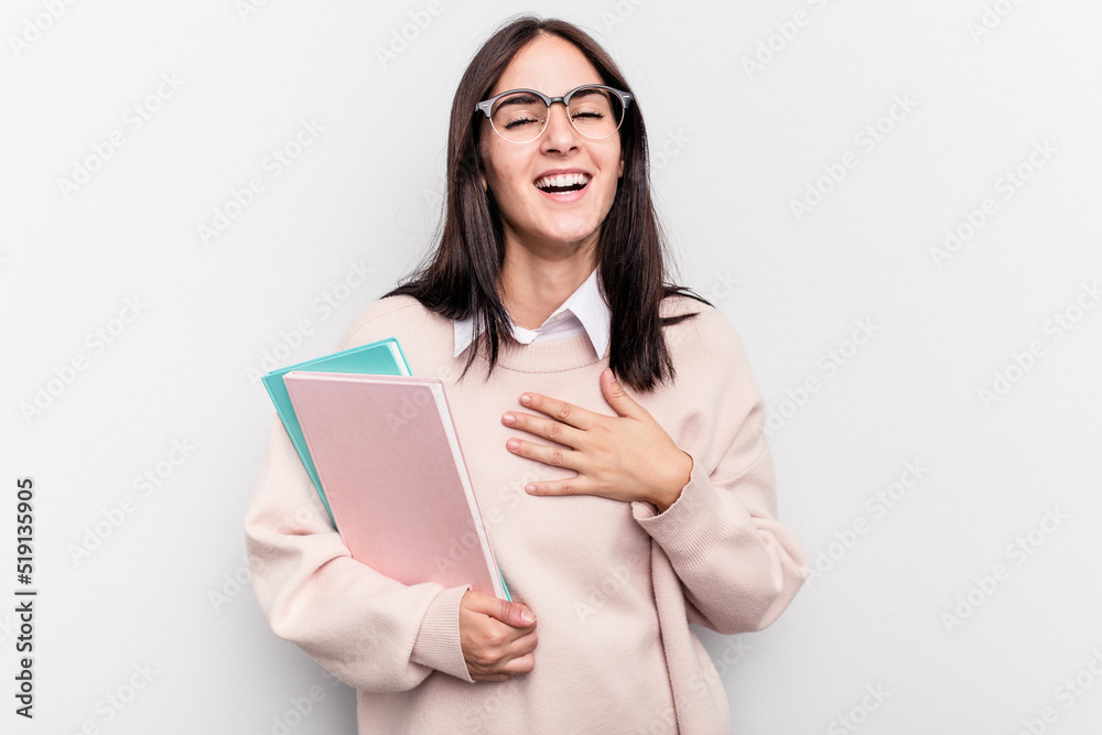 Young student caucasian woman isolated on white background laughs out loudly keeping hand on chest. Young student caucasian woman isolated on white background laughs out loudly keeping hand on chest.